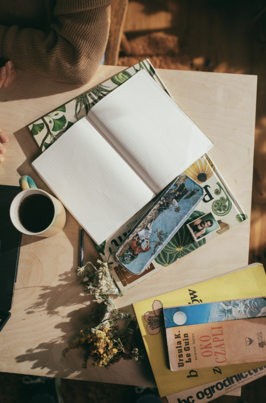 Open book and coffee cup on a table, soft light